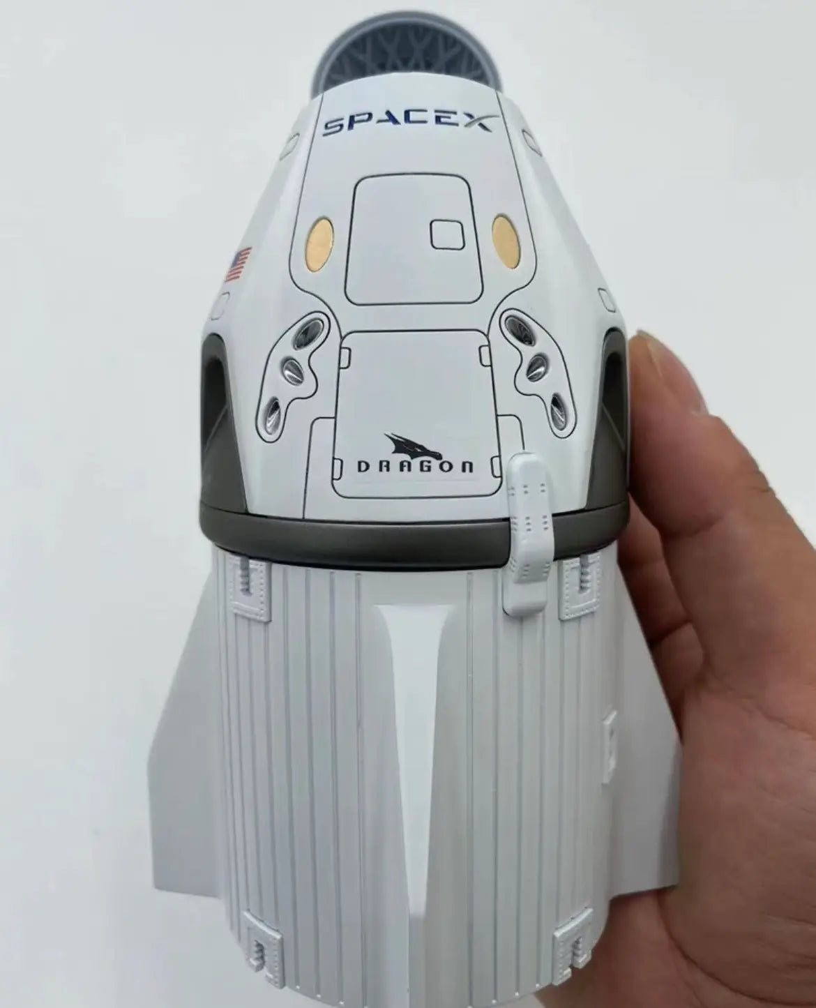 CrewDragon 1:55 model in hand, with open nose cone