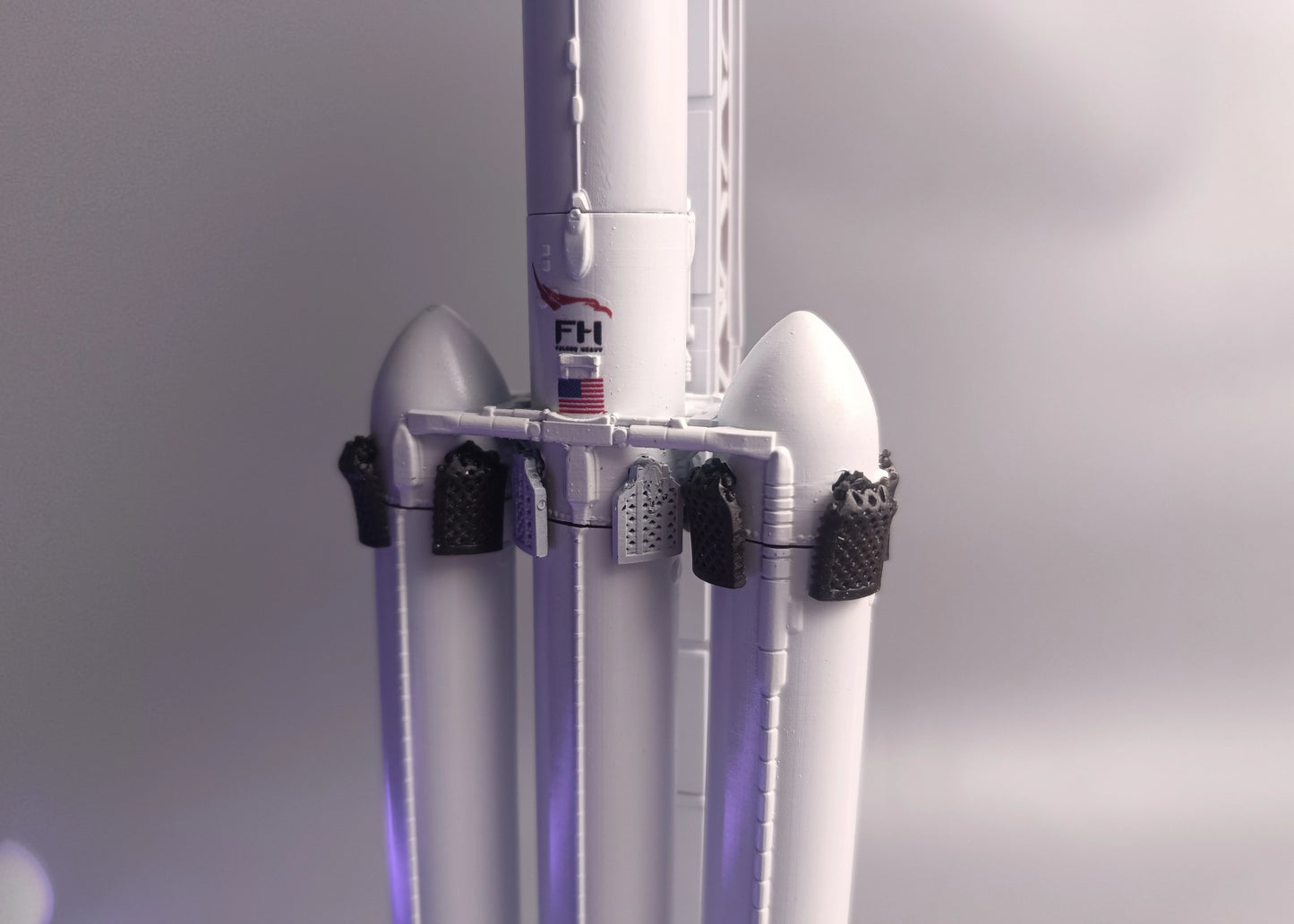 Grid rudders and the FH logo on the first stage of the Falcon Heavy rocket. SpaceX rocket model in 1:200 scale